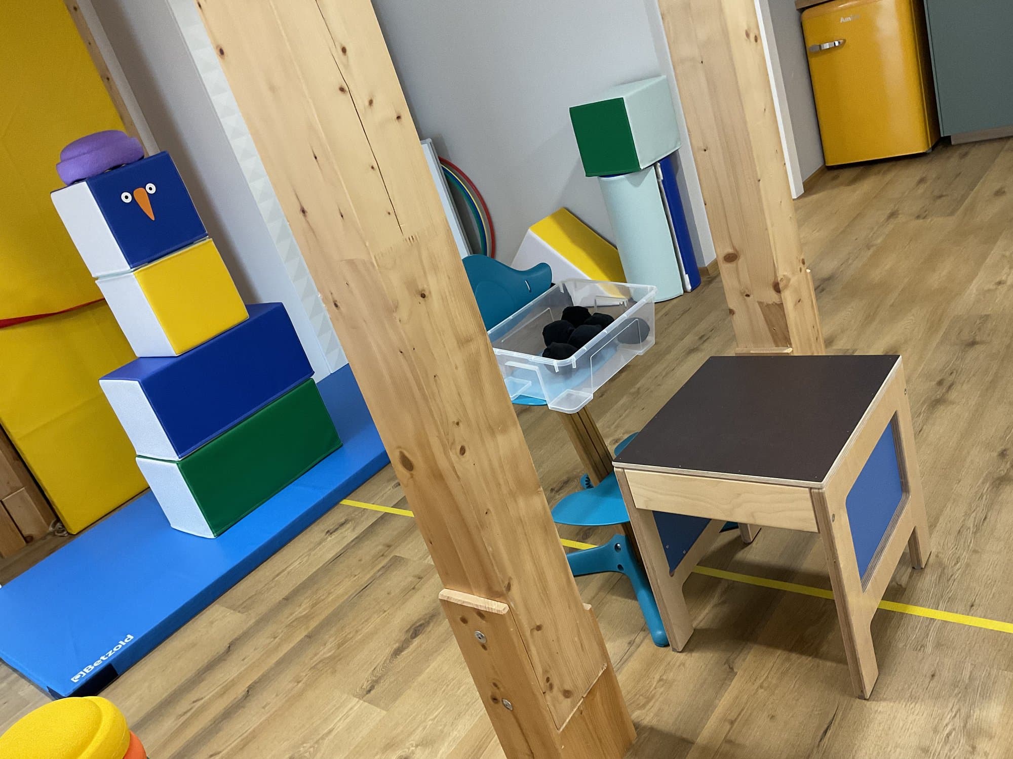 Bewegungsraum mit Softbausteinen, Turnmatte, Hocker und Holzbalken