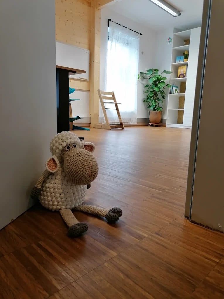 Gehäkeltes Schaf am Eingang des hellen Therapieraums mit Holzboden