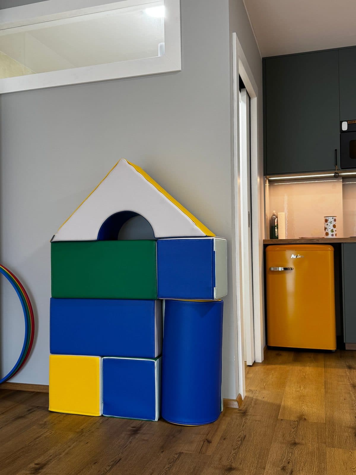 Haus aus bunten Softbausteinen im Therapieraum, daneben ein Gymnastikreifen